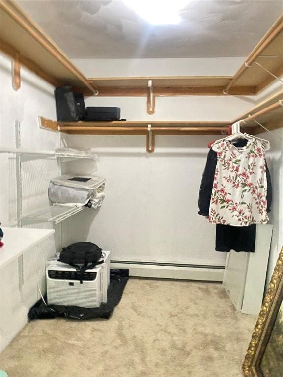 walk in closet featuring baseboard heating and light colored carpet