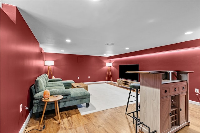 living area featuring light wood-style flooring, visible vents, baseboards, and recessed lighting