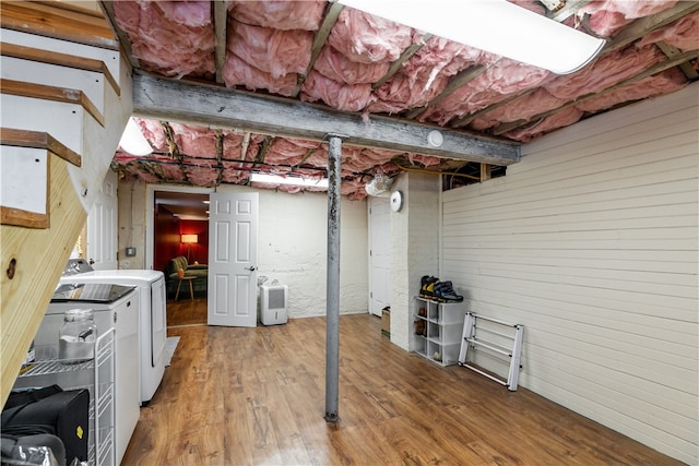 unfinished basement with wood finished floors and separate washer and dryer