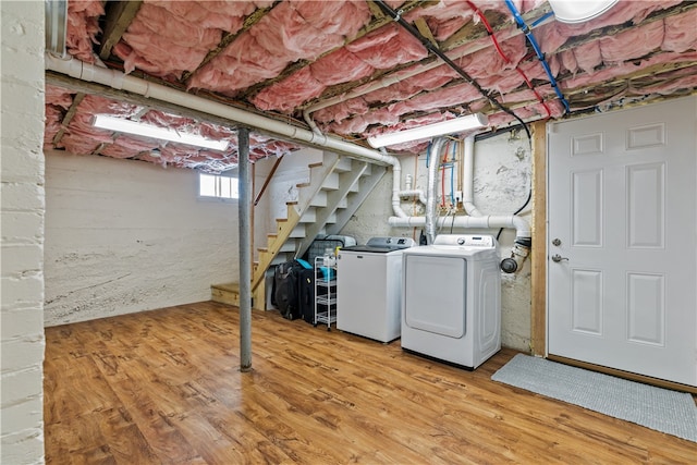 basement featuring washing machine and dryer, stairs, and wood finished floors