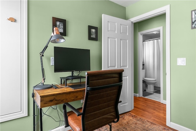 home office featuring wood finished floors and baseboards