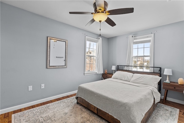 bedroom with wood finished floors, a ceiling fan, and baseboards