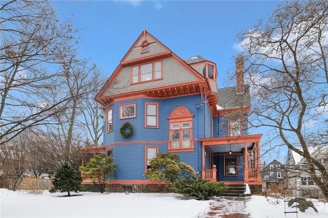 victorian home featuring covered porch and a chimney