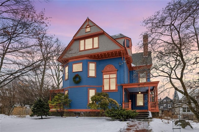 victorian home with covered porch and a chimney