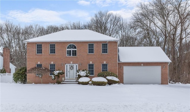 colonial house featuring brick siding and an attached garage