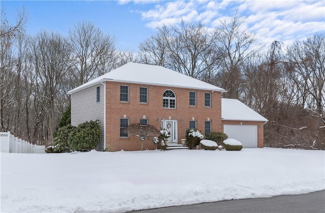 colonial-style house with an attached garage and brick siding