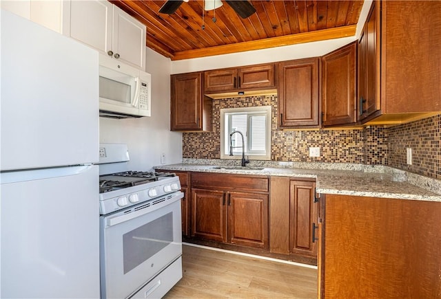 kitchen featuring decorative backsplash, brown cabinetry, wood ceiling, a sink, and white appliances