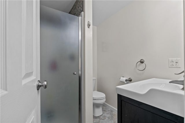 bathroom with toilet, a shower stall, baseboards, and vanity