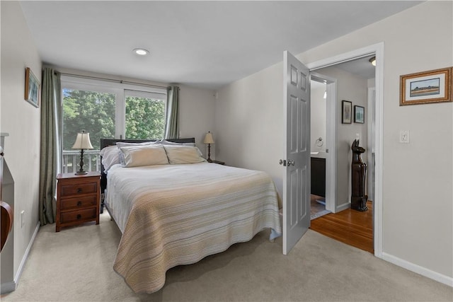 bedroom with baseboards and light colored carpet