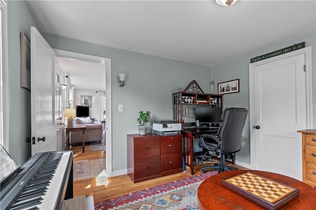 home office with light wood finished floors and baseboards