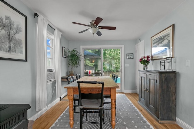 dining area featuring light wood-style floors, baseboards, and a ceiling fan