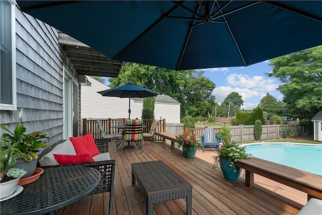 wooden deck with fence, outdoor dining area, and a fenced in pool