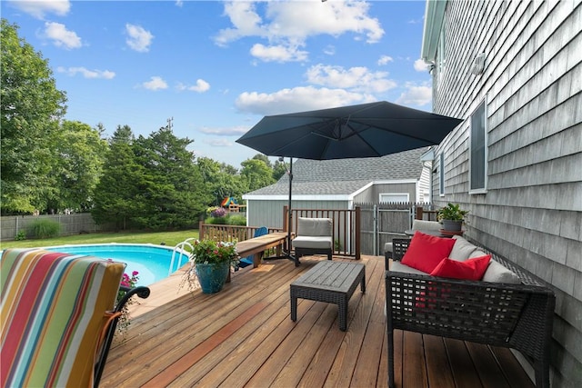 deck featuring a fenced in pool, fence, and an outdoor living space