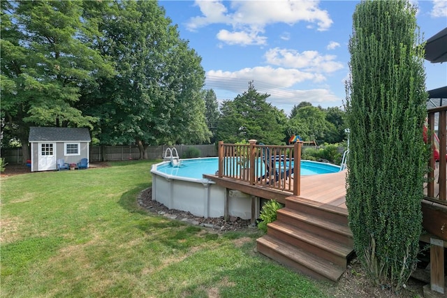 view of swimming pool featuring a deck, an outdoor structure, a fenced backyard, and a fenced in pool