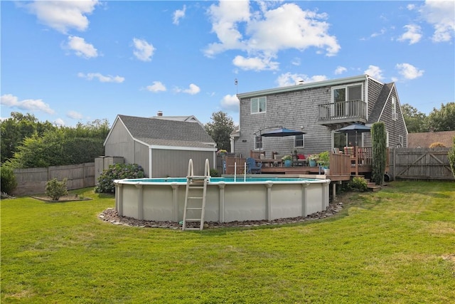 back of house featuring a fenced in pool, a fenced backyard, a lawn, and a balcony