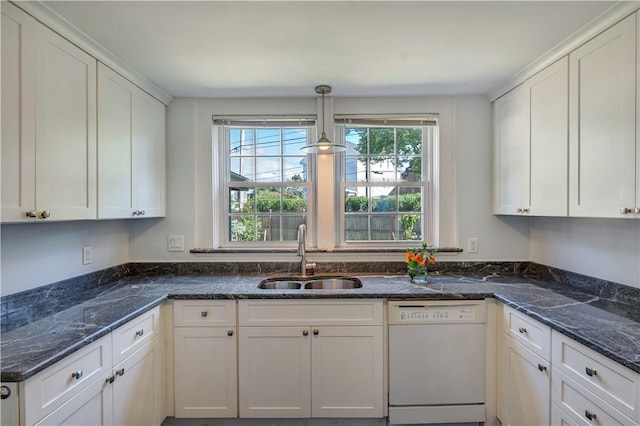 kitchen with white dishwasher, a sink, white cabinets, hanging light fixtures, and dark stone countertops