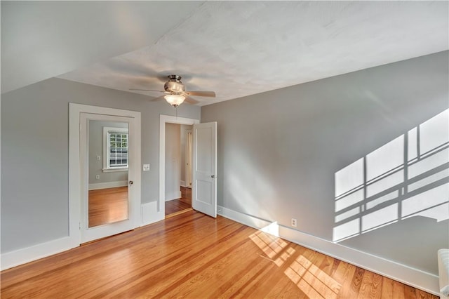 empty room featuring light wood finished floors, ceiling fan, and baseboards