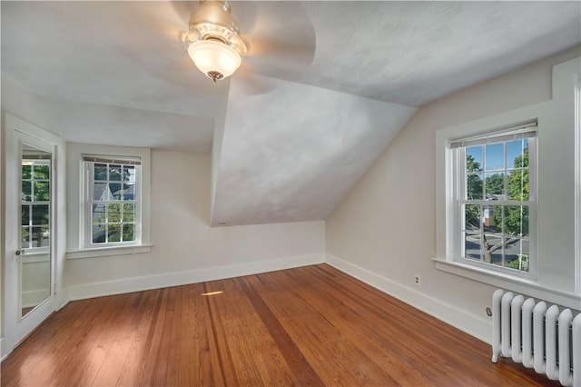 bonus room featuring radiator, a healthy amount of sunlight, and baseboards