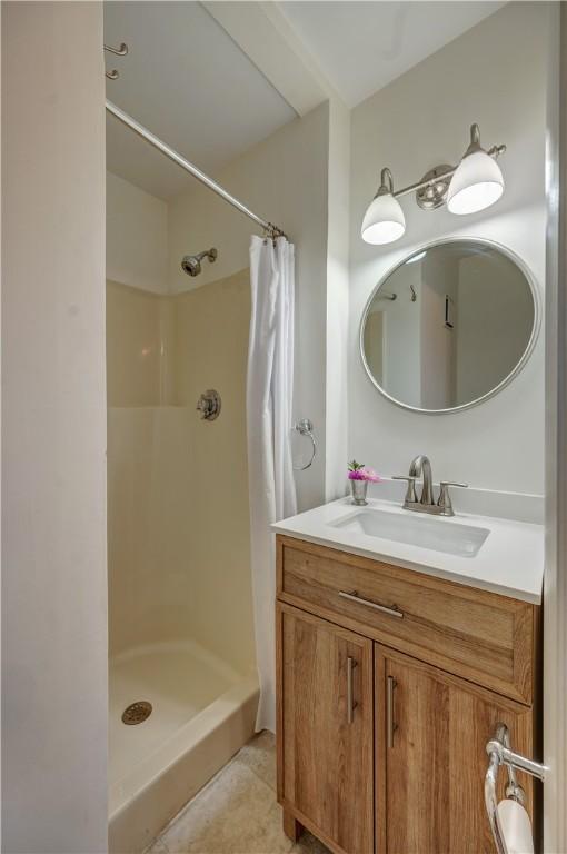 bathroom featuring a stall shower, tile patterned flooring, and vanity