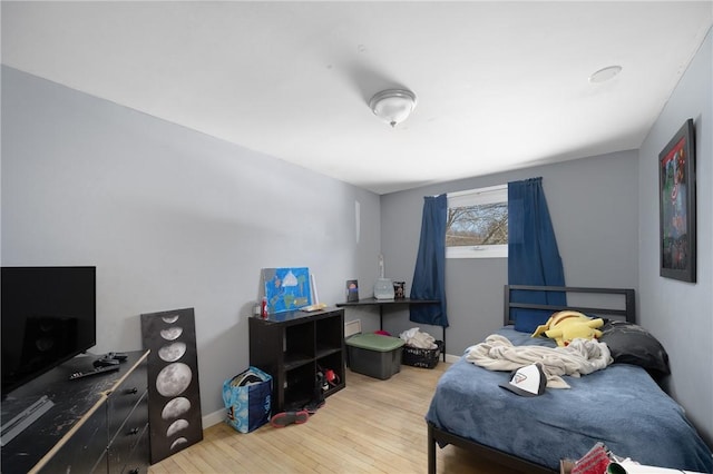 bedroom featuring baseboards and light wood finished floors