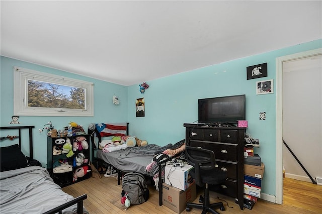 bedroom featuring light wood finished floors and baseboards