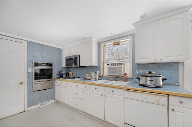 kitchen with a warming drawer, light countertops, decorative backsplash, appliances with stainless steel finishes, and white cabinetry