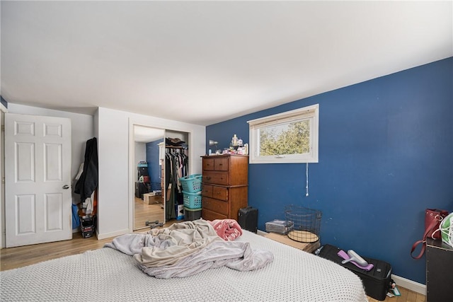 bedroom featuring a closet, baseboards, and wood finished floors