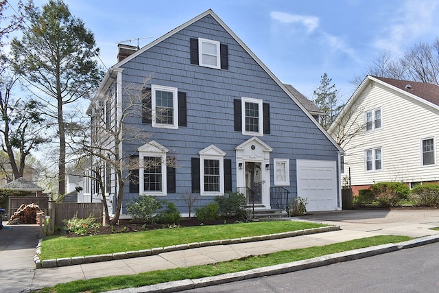 view of front of property featuring a garage, fence, and driveway