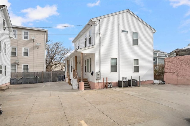 rear view of house with fence and cooling unit