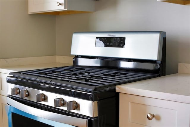 kitchen with light countertops, white cabinets, and stainless steel gas stove