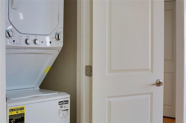 clothes washing area with stacked washing maching and dryer and laundry area