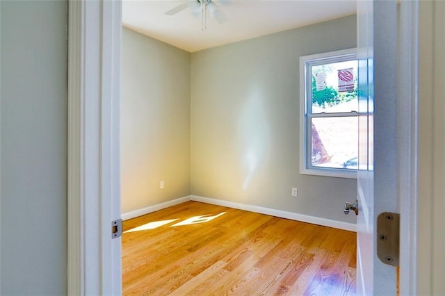 empty room with light wood-type flooring, ceiling fan, and baseboards