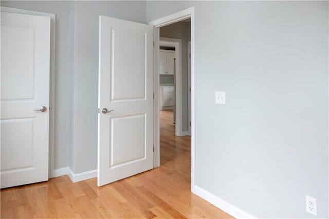 unfurnished bedroom featuring light wood-type flooring and baseboards