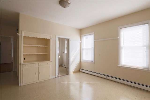 spare room with a baseboard heating unit, light floors, and baseboard heating