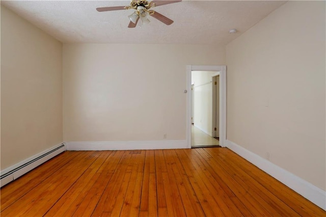 spare room featuring ceiling fan, light wood-type flooring, a baseboard radiator, and baseboards