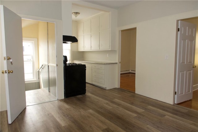 kitchen with a baseboard radiator, light countertops, stove, white cabinetry, and exhaust hood