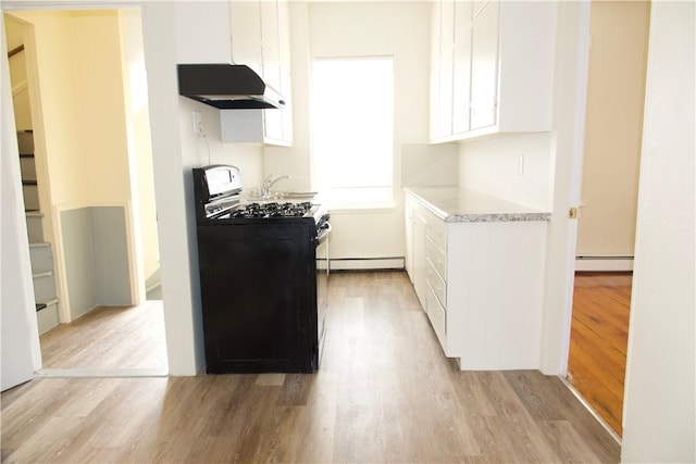 kitchen with gas stove, light countertops, under cabinet range hood, and white cabinetry