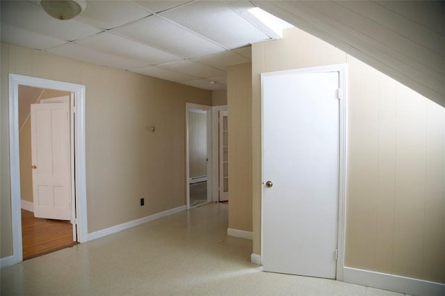 interior space with a drop ceiling and baseboards