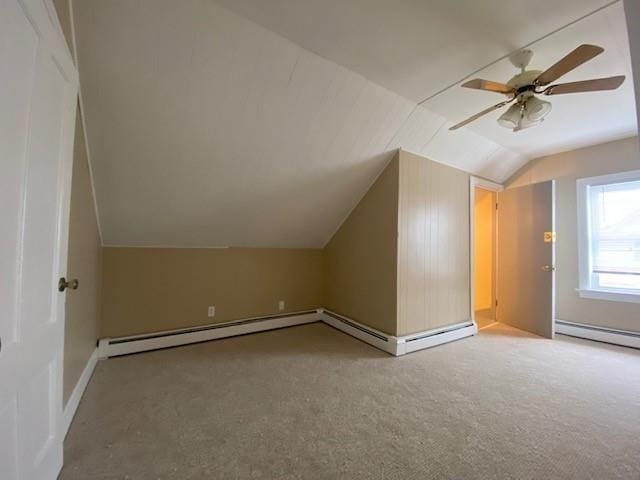 additional living space with a baseboard radiator, light colored carpet, a baseboard heating unit, a ceiling fan, and vaulted ceiling