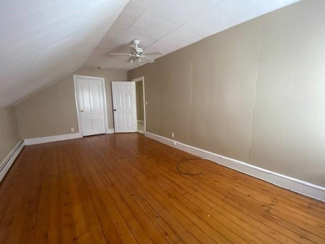 additional living space featuring lofted ceiling, wood finished floors, a ceiling fan, and baseboards