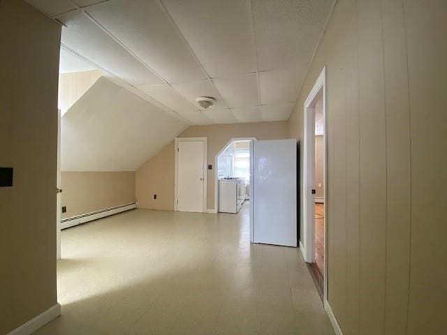 additional living space featuring lofted ceiling, baseboard heating, and tile patterned floors