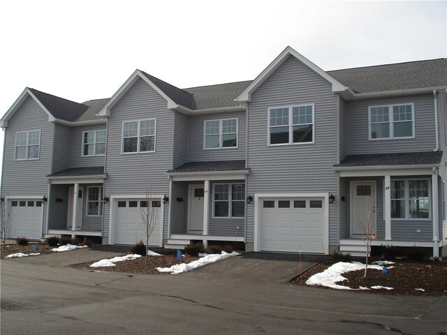 view of front of home featuring aphalt driveway, roof with shingles, and an attached garage