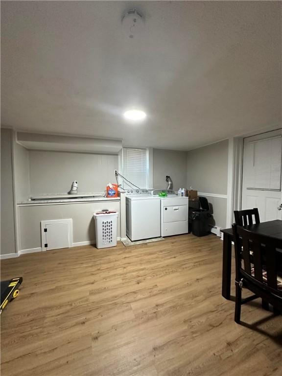 washroom featuring light wood-style floors, laundry area, independent washer and dryer, and baseboards