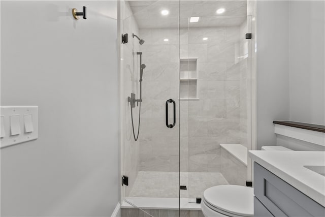 full bathroom featuring toilet, a stall shower, and vanity