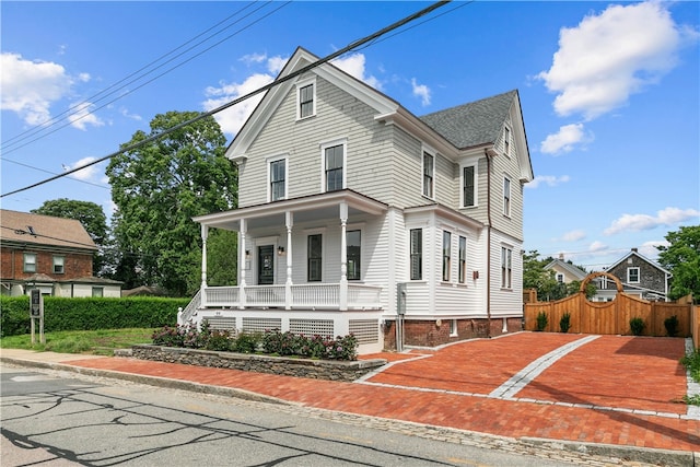 view of front of home with covered porch and fence