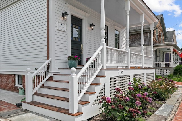 view of exterior entry featuring covered porch