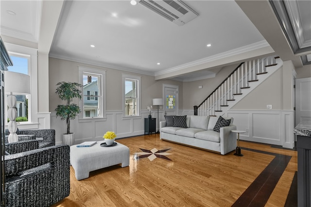 living area featuring visible vents, light wood-style flooring, stairway, ornamental molding, and recessed lighting