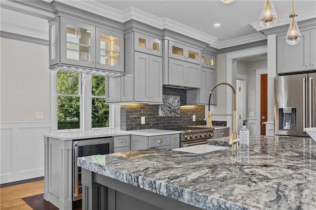 kitchen with glass insert cabinets, wine cooler, stone counters, and stainless steel refrigerator with ice dispenser