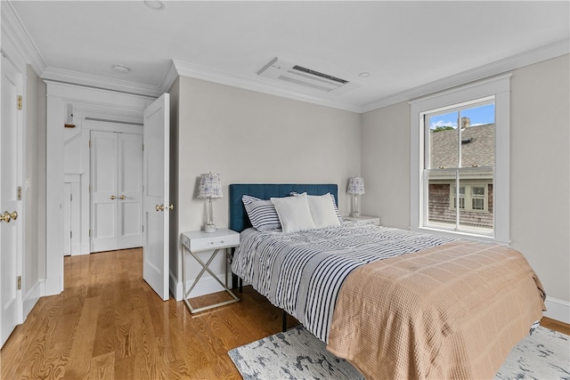 bedroom featuring ornamental molding, baseboards, and wood finished floors