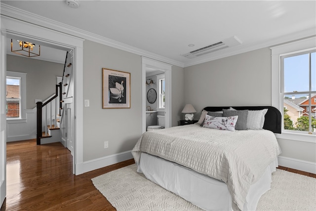 bedroom featuring baseboards, wood finished floors, and crown molding